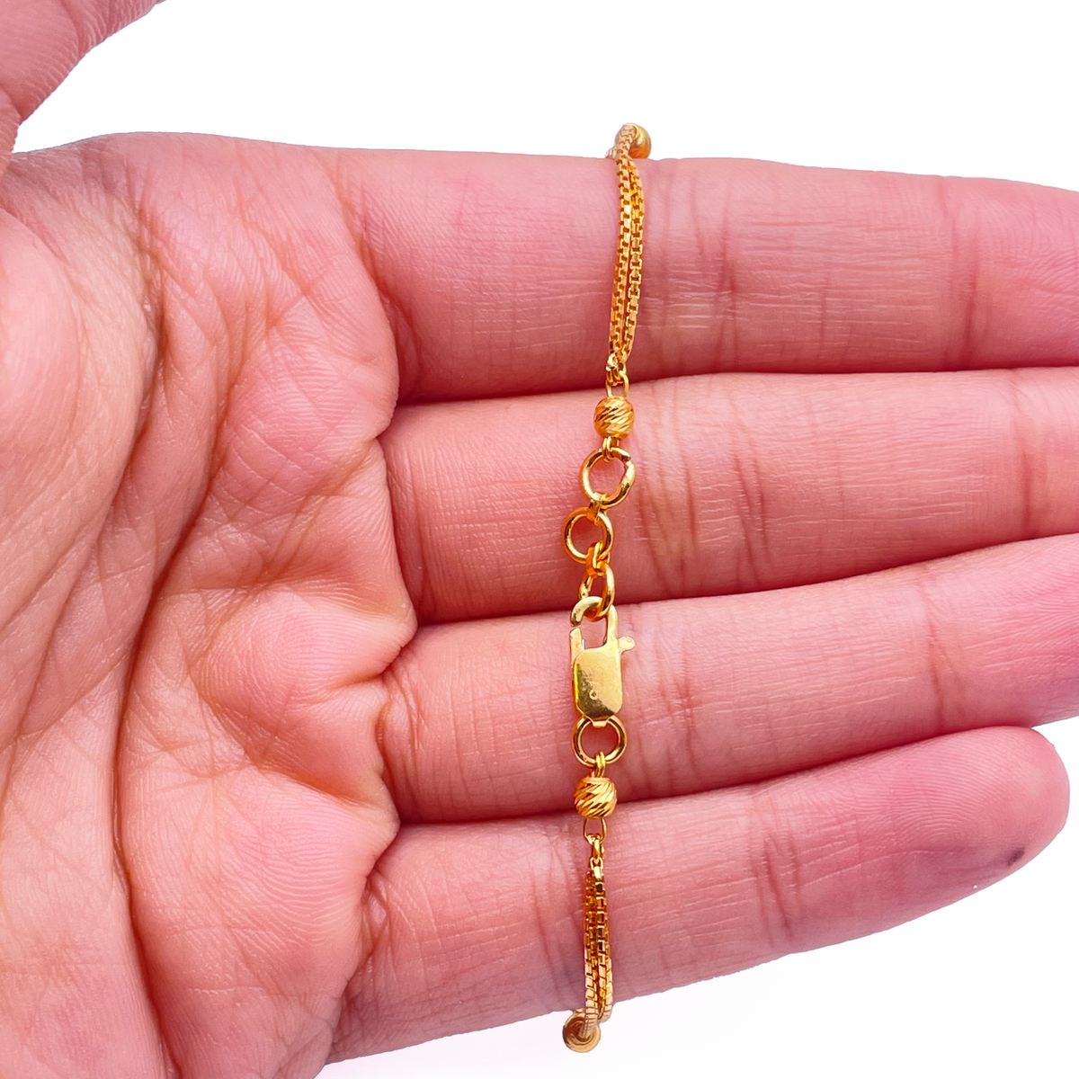 Bracelet double chaîne en or jaune 22 carats avec perles taillées en diamant