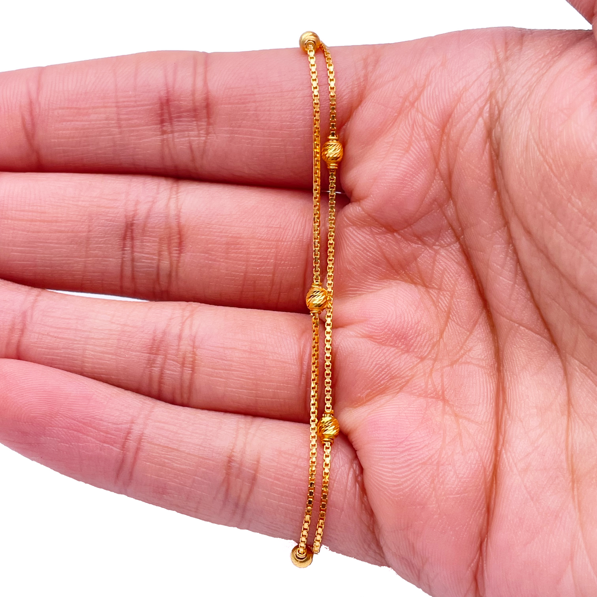 Bracelet double chaîne en or jaune 22 carats avec perles taillées en diamant